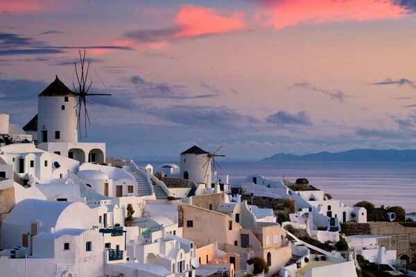 Las paredes blancas de una hermosa ciudad junto al mar en los rayos del atardecer