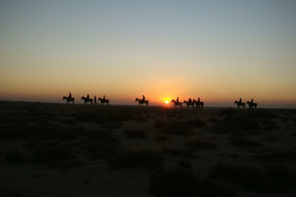 Le persone a cavallo vagano nel deserto