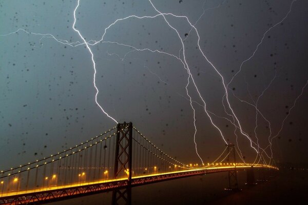 Night bridge on the background of lightning