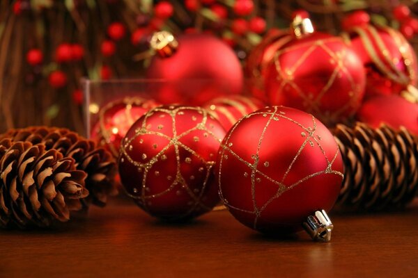 Boules de Noël et cônes sur fond rouge