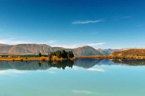 Autumn landscape. Mountain lake, mountains, blue sky