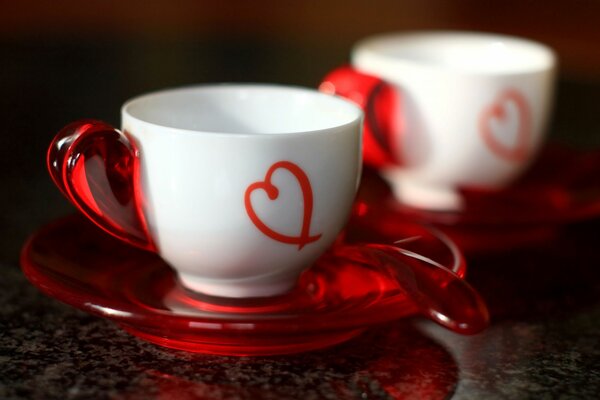 Two white cups with hearts