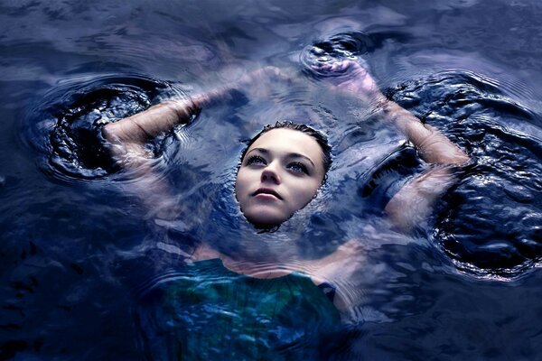 Красивая девушка лежит в воде