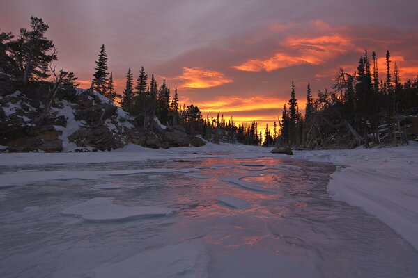 Scharlachroter Sonnenuntergang am Winterabend am Fluss