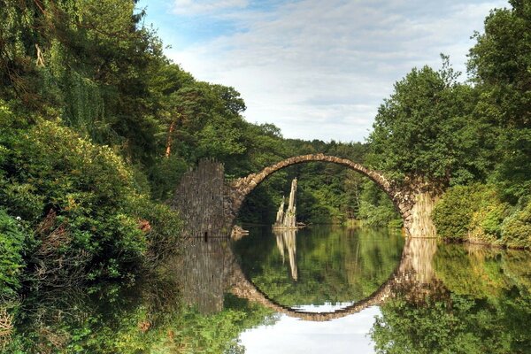 Ponte rotondo con riflessione in mezzo alla natura