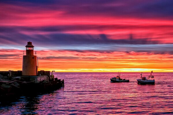 Pôr do sol brilhante no mar com farol