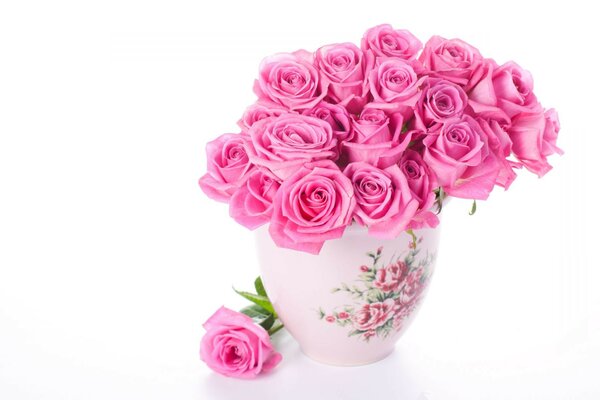 A vase of pink roses is on the table