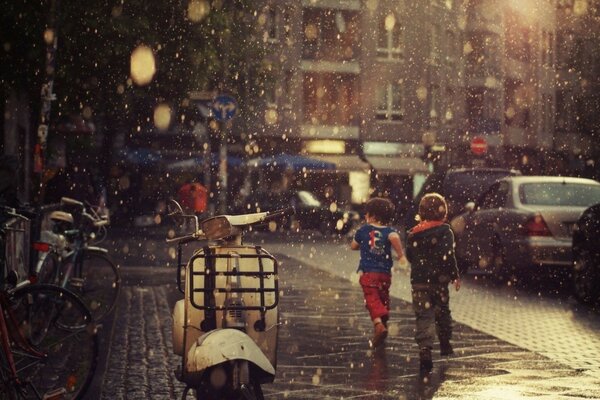 Enfants en cours d exécution à l abri de la pluie qui commence