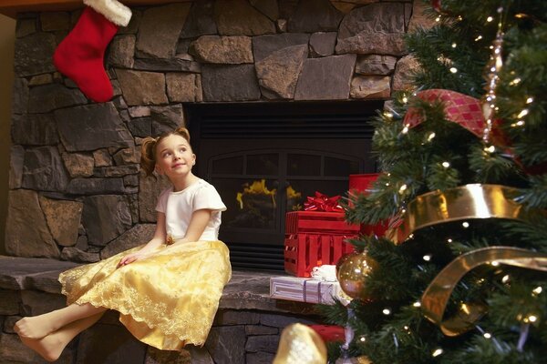 L attente d un miracle. Petite fille près de la cheminée et habillé arbre de Noël. Serpentin