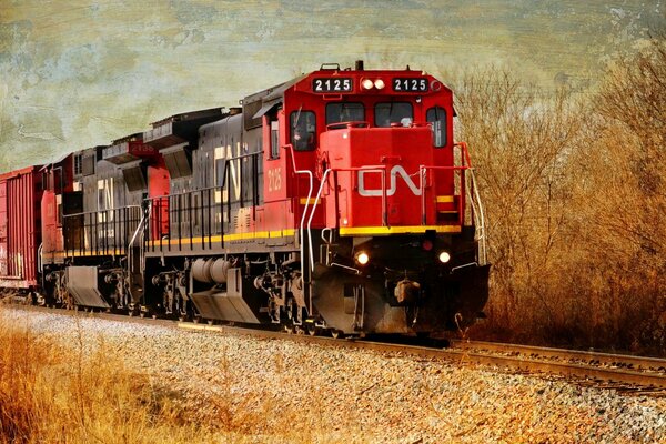 Красный локомотив едет по железной дороге