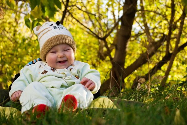 Bambino felice nel parco seduto sulla lettiera