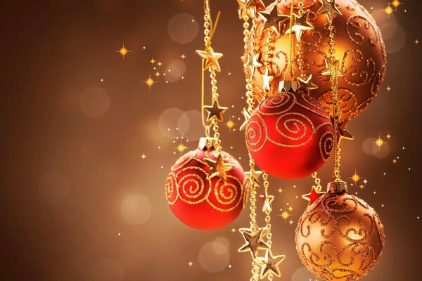 क्रिसमस ट्री सजावट। सोने की पेंटिंग के साथ लाल क्रिसमस गेंदें । क्रिसमस गेंदों और सितारों का एक गुच्छा