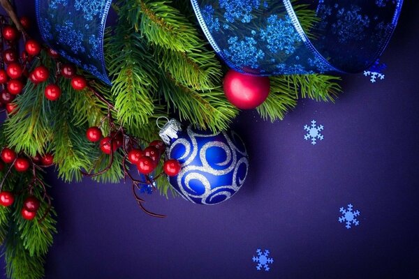 New Year s ball with ribbons on a branch of a fir tree