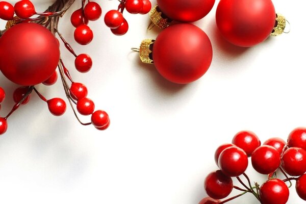 Red berry beads and Christmas balls on a white background