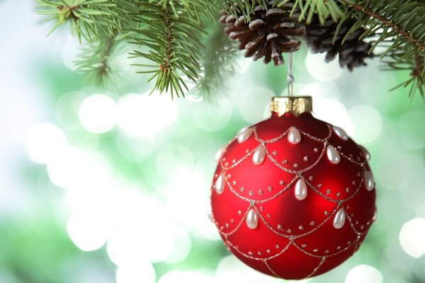 Decoração de Natal. Ano. Uma bola vermelha com gotas brancas de pérolas. Bolas de Natal requintadas