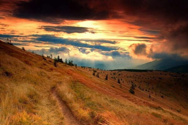 Puesta de sol carmesí en terreno montañoso