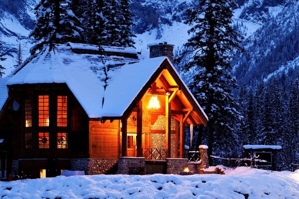 Casa nelle montagne innevate della foresta invernale