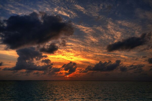 Sonnenuntergang Himmel mit Wolken, die über dem Wasser hängen