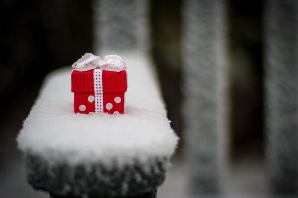 Un pequeño regalo en un muñón cubierto de nieve