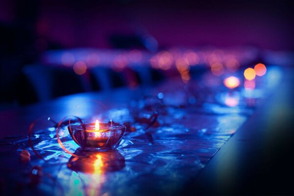 A table on a blurry background with a burning candle