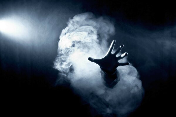 A hand emerging from the white mist