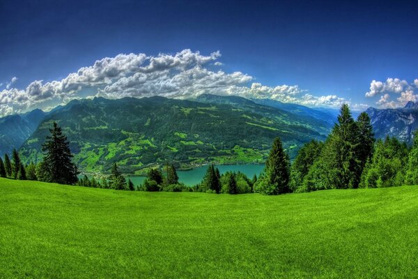 A picturesque valley with a lake and white clouds