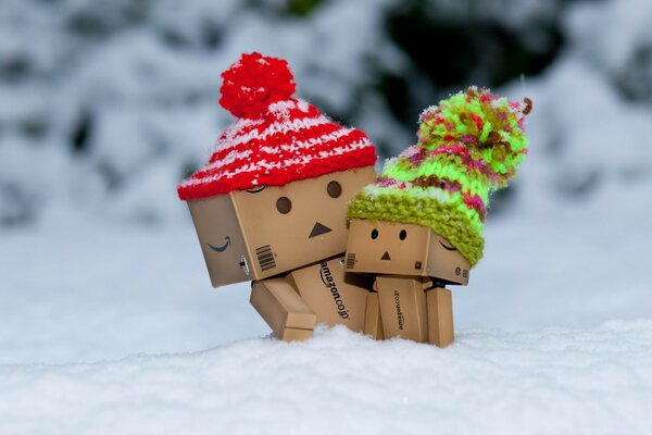 Figuras de cartón con sombreros en la nieve