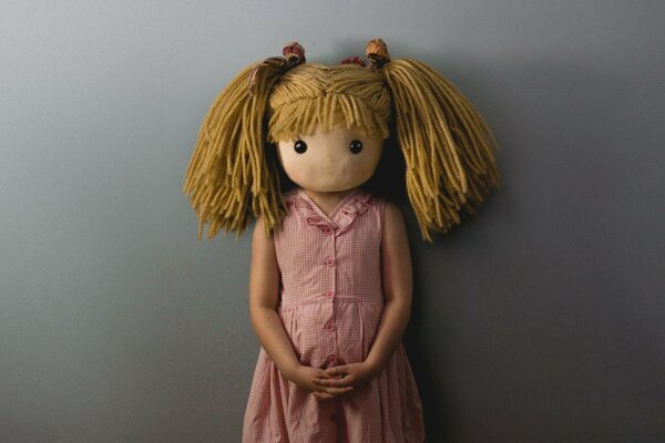 一个年轻女孩与娃娃的头的肖像
