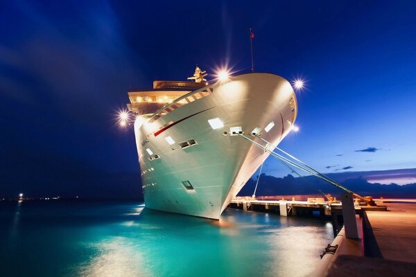 A ship on a pier on blue water