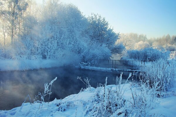 Bridge over the river. Winter snowy landscape