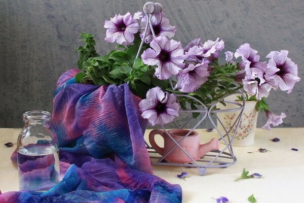 Arreglo de flores con un pañuelo y una jarra de agua