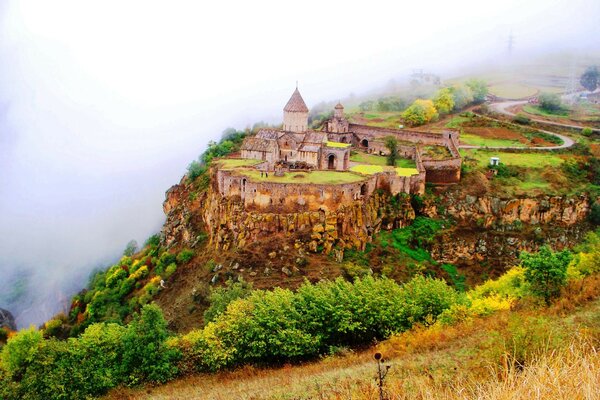 Antigua iglesia al borde de un barranco verde