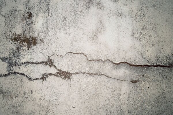 Part of a grey cement wall with a crack