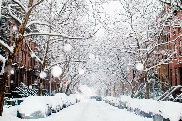 Winter city in snowdrifts and cars