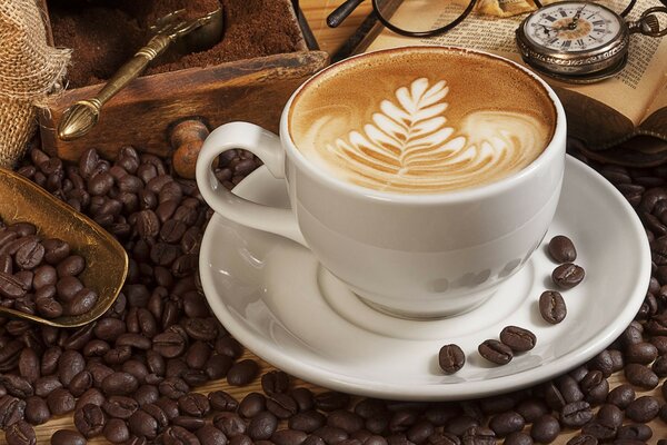 A cup of coffee with beans on a saucer