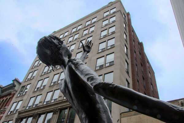 Sculpture of a man on the background of a high-rise building