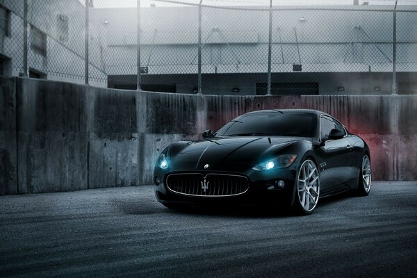 Sports car in the city on the background of a fence