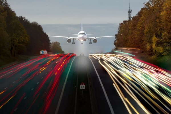 The plane is flying over the expressway