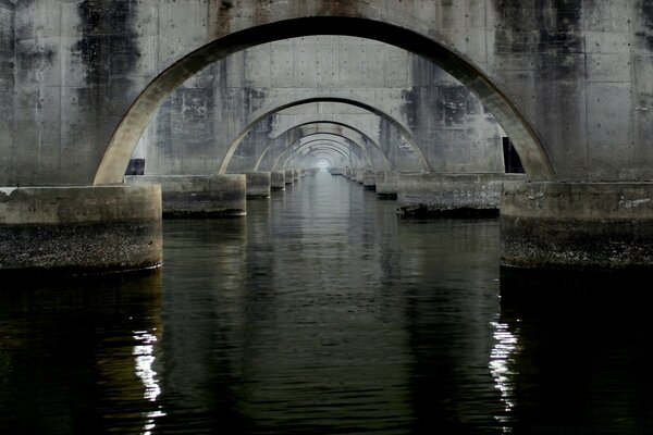 Reflejo de los arcos del puente en el agua