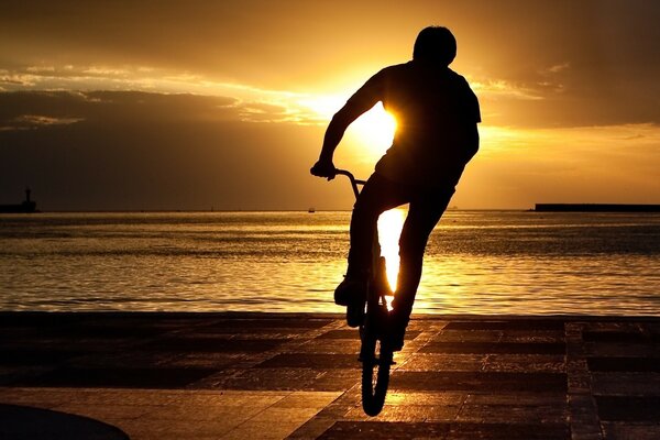 Guy performs bunny hop on the pier