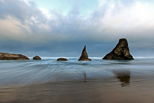 Four rocks sticking out of the sea surface