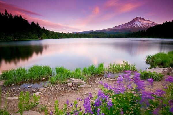 Um pôr do sol extraordinariamente belo contra o fundo do lago e das montanhas