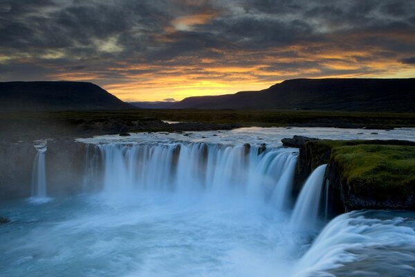 There are many waterfalls at sunset in the mountains