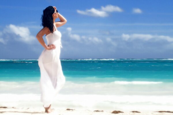 Chica modelo en blanco en la playa de verano