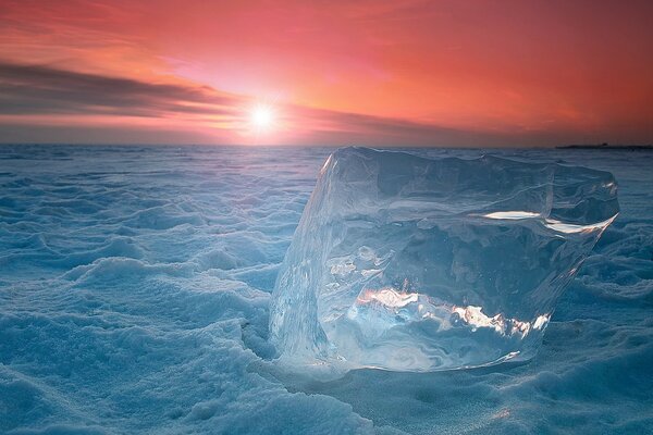 A large piece of ice on the background of a red sunset