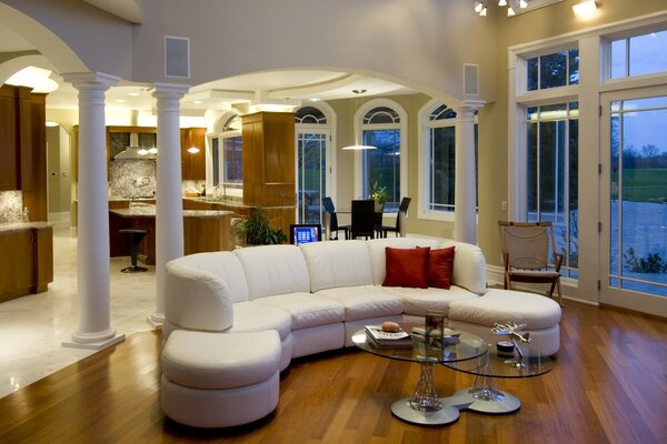 A room with a white leather sofa and columns