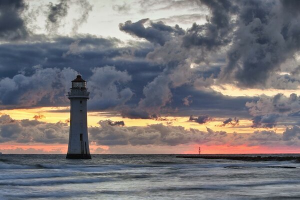 Leuchtturm im Meer vor dem Hintergrund der Wolken