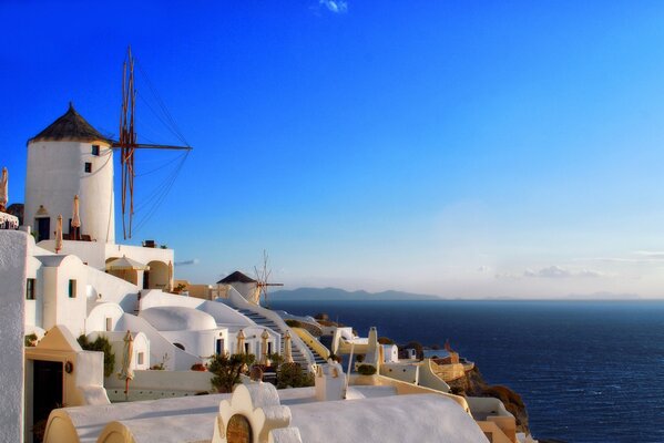 Phare blanc comme neige sur le ciel bleu au bord de l eau