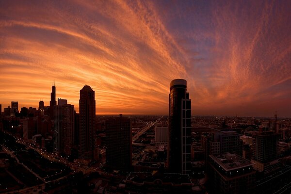 Grattacieli sotto il cielo rosso al tramonto