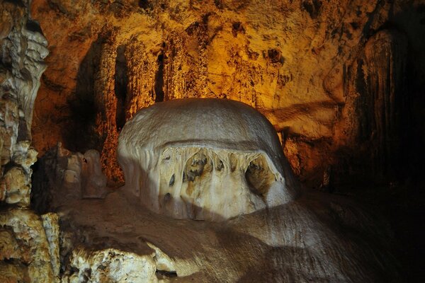 Von oben beleuchtete Höhle mit braunen Wänden